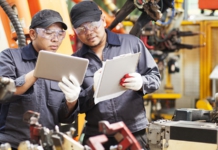manufacturing workers with tablets for quality management system